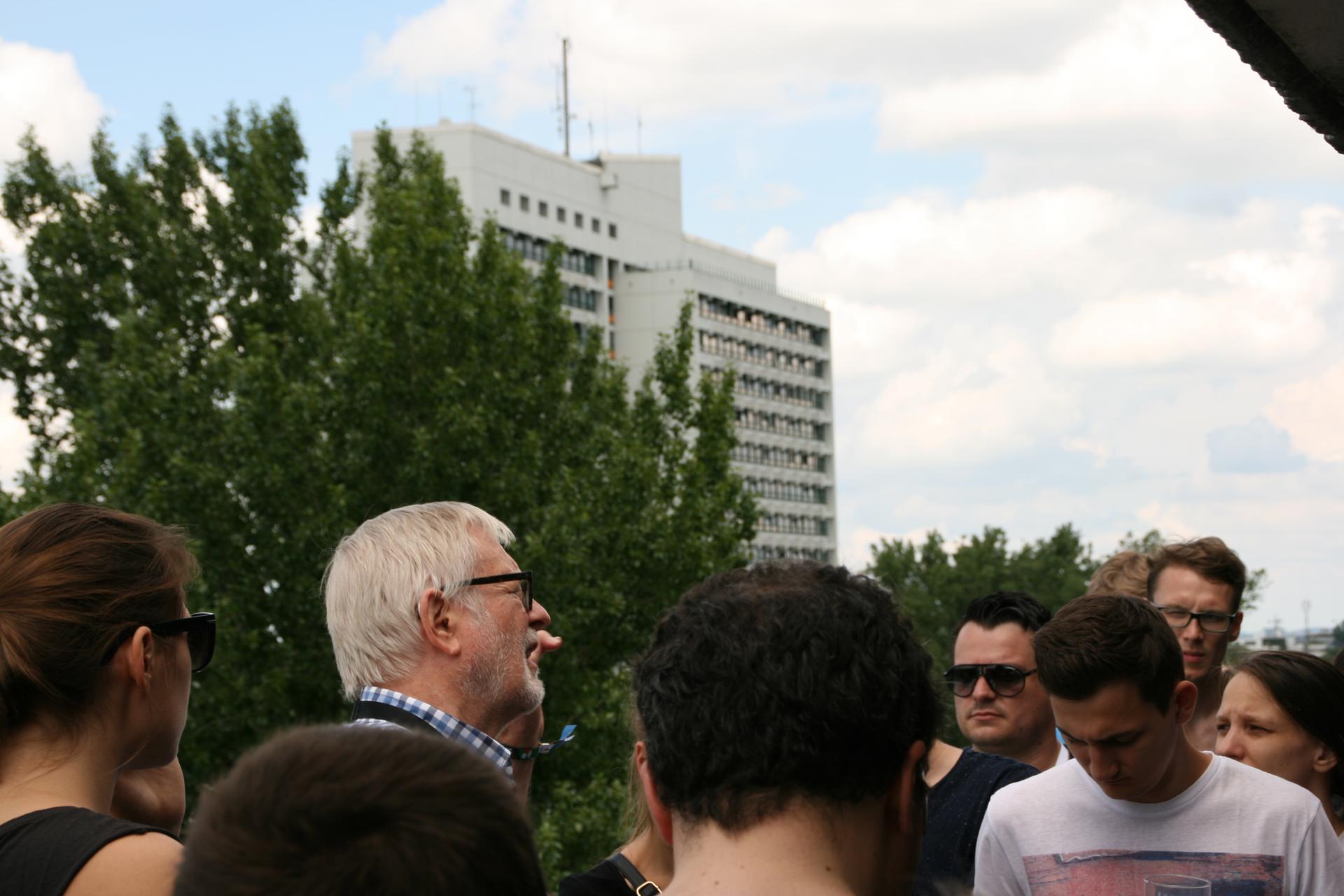 Helmut Gierke auf dem MKH-Dach umringt von etwa 10 (sichtbaren) Personen. Im Hintergrund das HSH