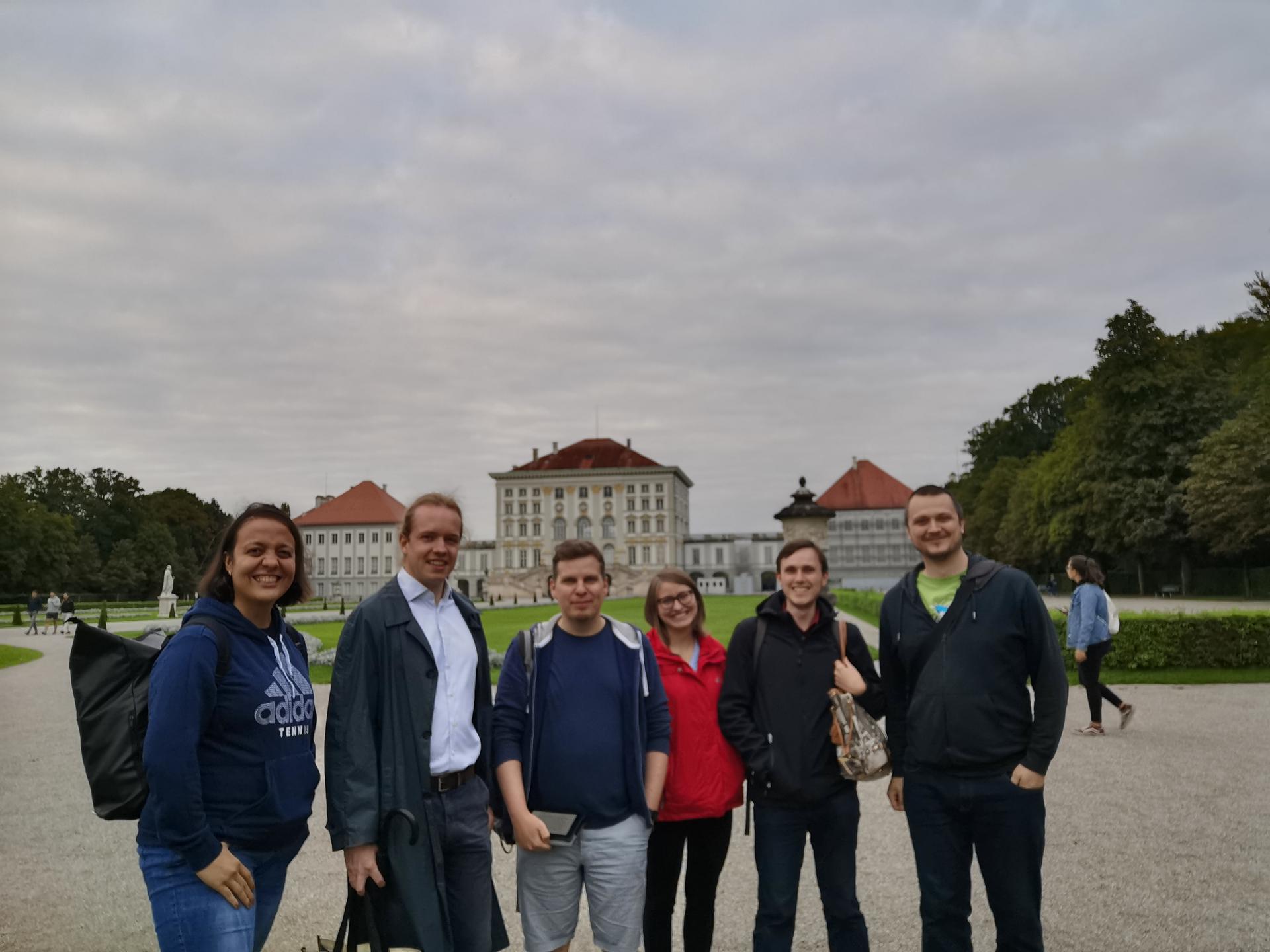Sechs Personen vor dem Schloss Nymphenburg (Parkseite)