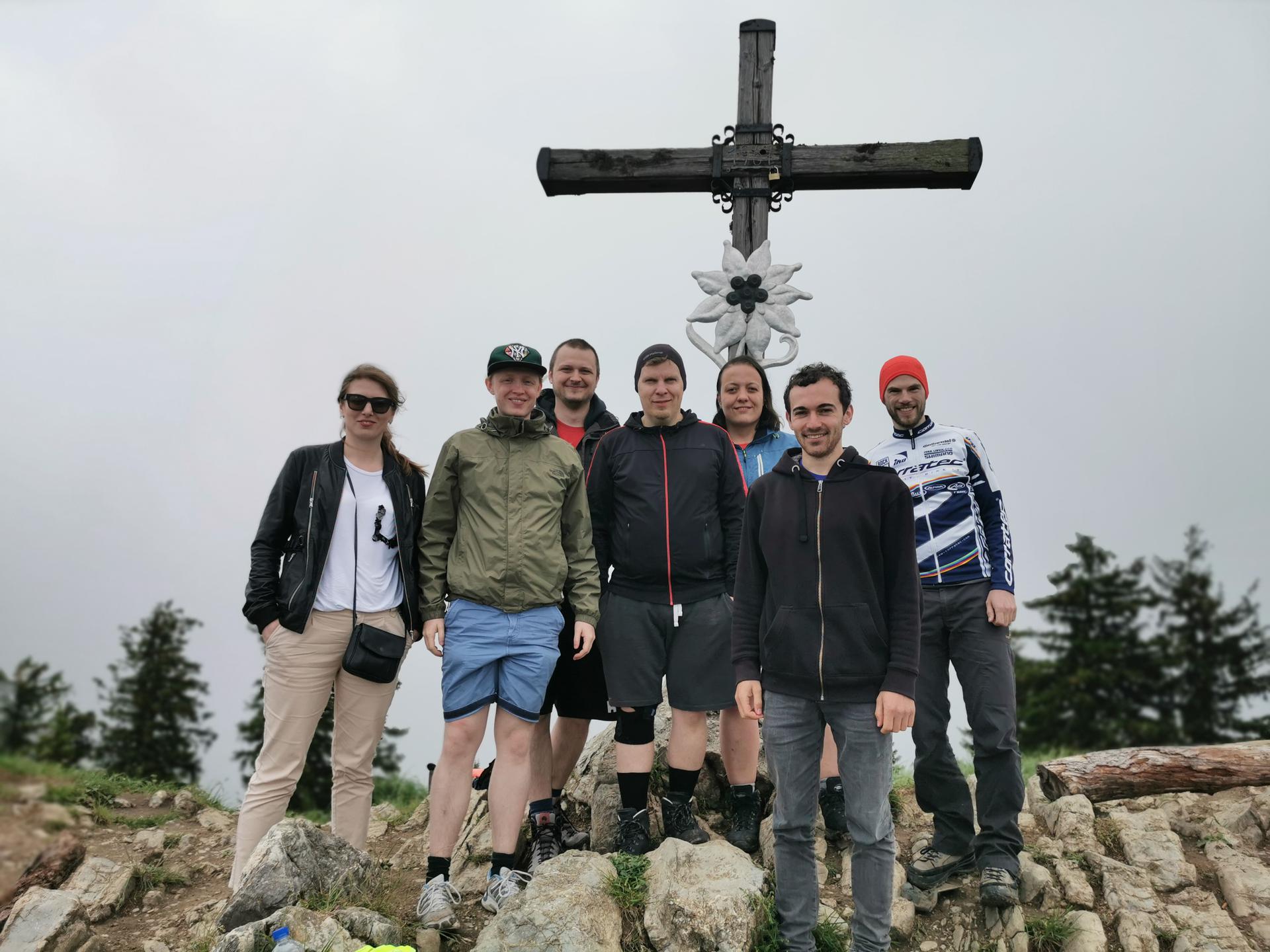 Die 7 Teilnehmenden stehen vor dem Gipfelkreuz des Heuberg
